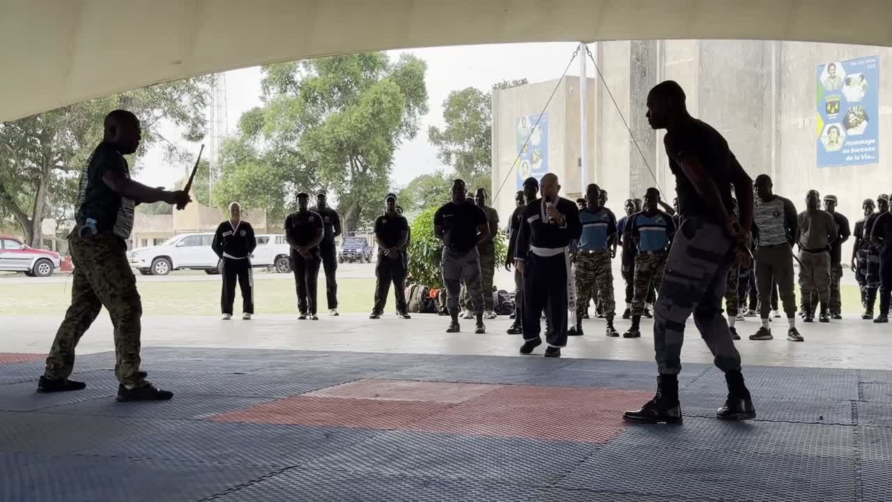 Démonstration de défense contre bâton devant les stagiaires